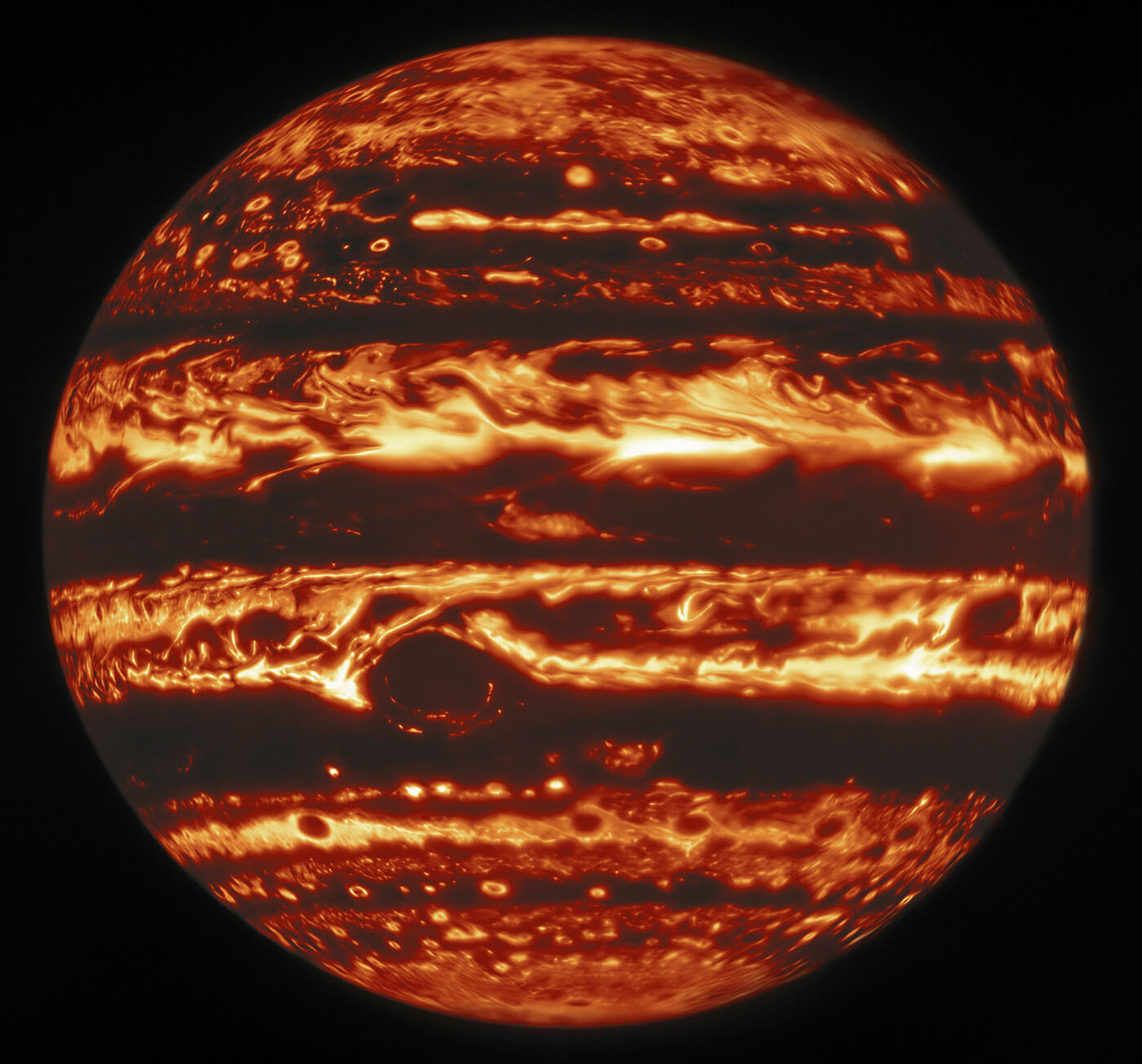 This infrared view of Jupiter was created from data captured on 11 January 2017 with the Near-InfraRed Imager (NIRI) instrument at Gemini North in Hawaiʻi, the northern member of the international Gemini Observatory, a Program of NSF’s NOIRLab. It is actually a mosaic of individual frames that were combined to produce a global portrait of the planet. In the image warmer areas appear bright, including four large hot spots that appear in a row just north of the equator. South of the equator, the oval-shaped and cloud-covered Great Red Spot appears dark.