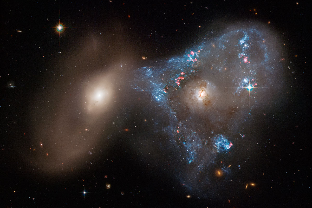 A spectacular head-on collision between two galaxies fueled the unusual triangular-shaped star-birthing frenzy, as captured in a new image from NASA's Hubble Space Telescope. The interacting galaxy duo is collectively called Arp 143. The pair contains the glittery, distorted, star-forming spiral galaxy NGC 2445 at right, along with its less flashy companion, NGC 2444 at left.