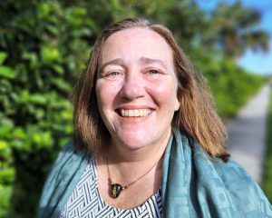 Smiling photo of Jean Toal Eisen in front of green trees