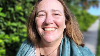 Smiling photo of Jean Toal Eisen in front of green trees