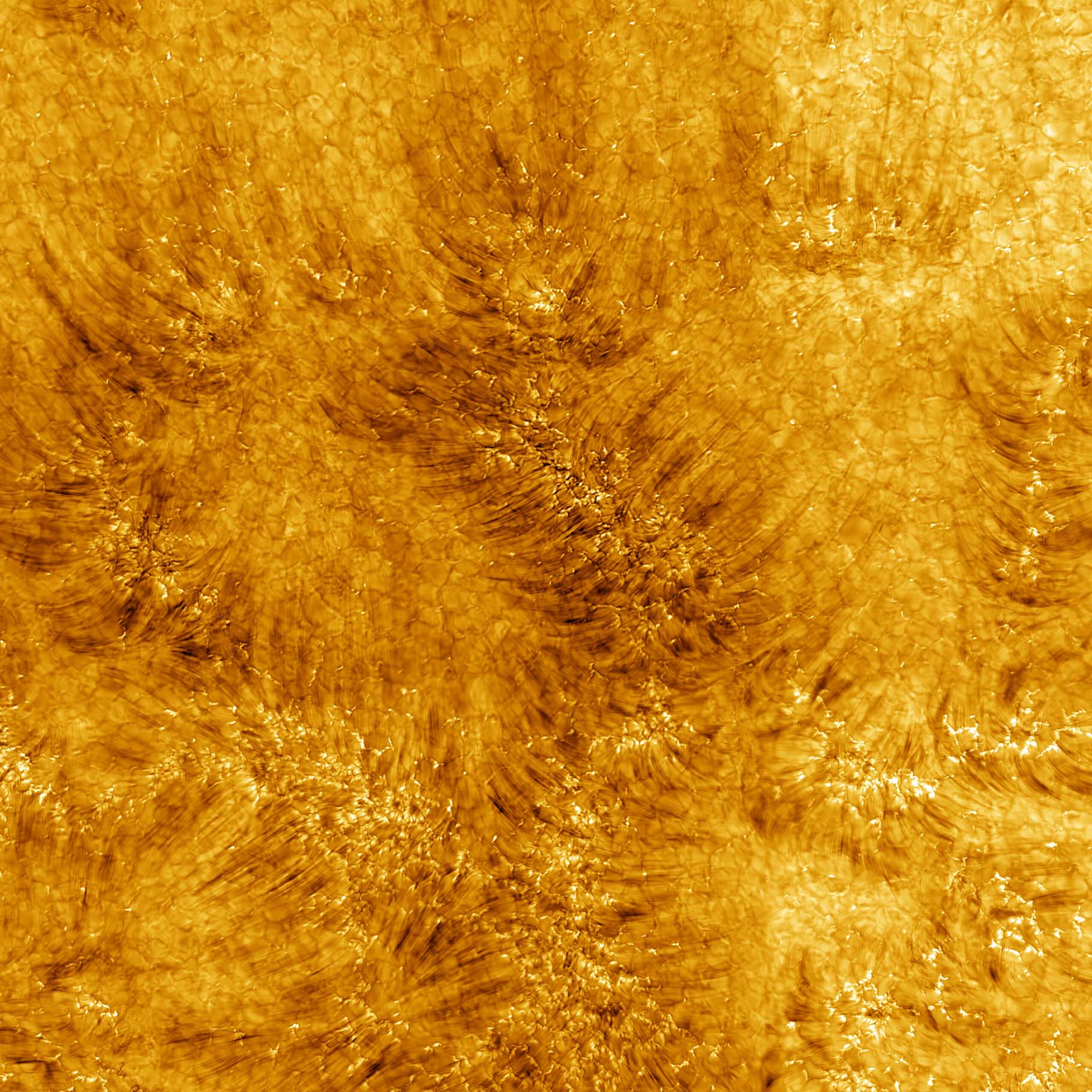 This image of the Sun's chromosphere shows turbulent motion with ridges of orange and yellow. Under the motion is a glimpse of the cellular structure of the Sun's surface.