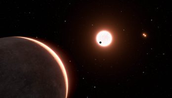 This is an artist's concept of the nearby exoplanet LTT 1445Ac, which is the size of Earth. The planet orbits a red dwarf star. The star is in a triple system, with two closely orbiting red dwarfs seen at upper right. The black dot in front of the bright light-red sphere at image center is planet LTT 1445Ac transiting the face of the star.