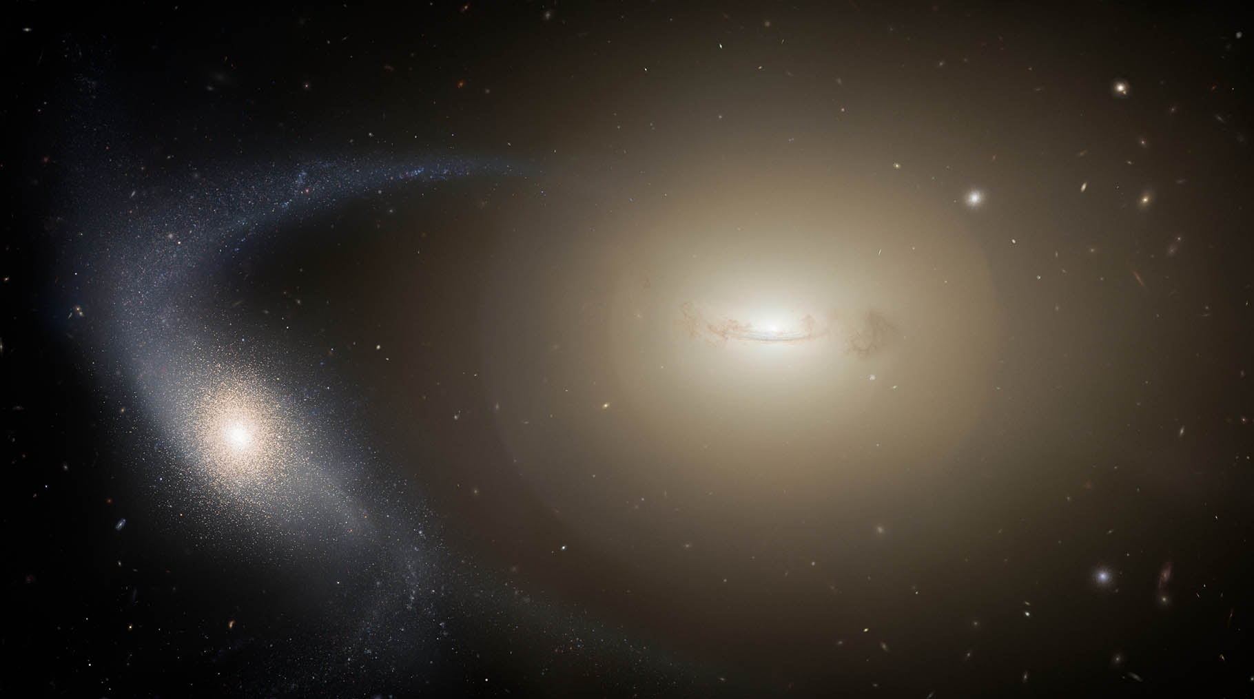 Artist’s impression of a dwarf galaxy undergoing tidal stripping, dark background with a light ball orbiting a glowing galaxy