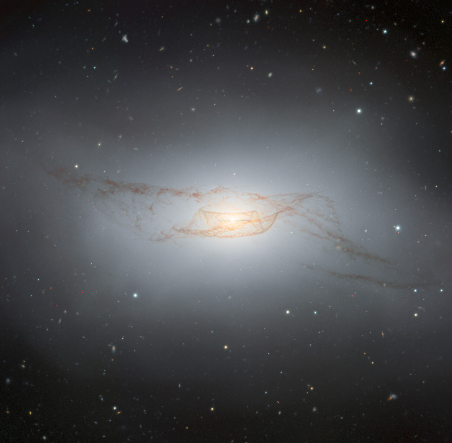 The lenticular galaxy NGC 4753, captured by the Gemini South telescope, one half of the International Gemini Observatory operated by NSF’s NOIRLab, is a truly remarkable object. Its prominent and complex network of dust lanes that twist around its galactic nucleus define its ‘peculiar’ classification and are the likely result of a galactic merger with a nearby dwarf galaxy about 1.3 billion years ago.