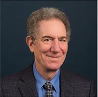 Head shot of smiling man on dark background