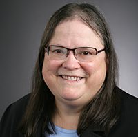 Headshot of smiling woman with glasses