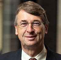Headshot of a man with glasses and a tie