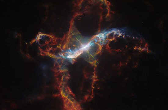 A bright binary star surrounded by a colorful nebula on the black background of space.