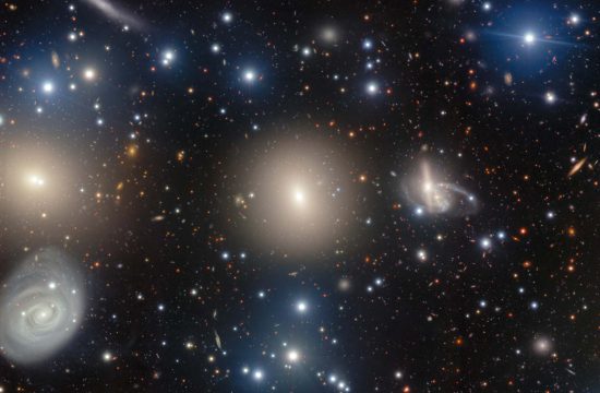 NGC 1270: A Galactic Archipelago is shown as glittering stars on a deep black background with large fuzzy halos of yellow