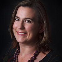 Head shot of a smiling Rachel Osten against a black background