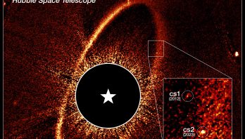 Image labeled Fomalhaut system, Hubble Space Telescope. A grainy orange oval ring tilts slightly from upper right to lower left. At two o'clock, a white box outlines the ring's edge and white lines extend to a larger pullout box at lower right. Two spots inside the larger box are marked with dashed white circles and labeled cs1 2012 and cs2 2023. Inside the ring is a black circle with a white star symbol in the middle.