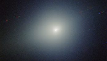 a bright light is in the center of the image is surrounded by a greenish glow on a dark black background.