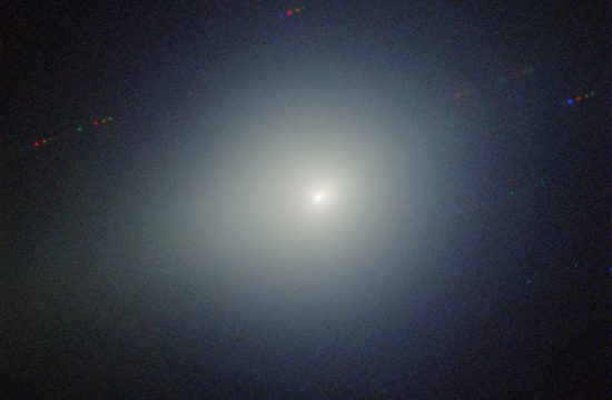 a bright light is in the center of the image is surrounded by a greenish glow on a dark black background.