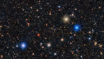A black background is filled with stars -small and large glowing white, red, yellow and blue.