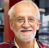 Head shot of older man with white hair and a beard.
