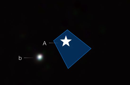 A black square labeled “29 Cyg” at upper right. In the middle, a white star symbol is surrounded by a small blue trapezoid that widens from upper left to lower right of the star. The star is labeled with a capital A. The trapezoid indicates where the star’s light has been blocked by a coronagraph. To the star’s left beyond the blue trapezoid at 8 o’clock is a fuzzy white blob labeled with a lower-case b.