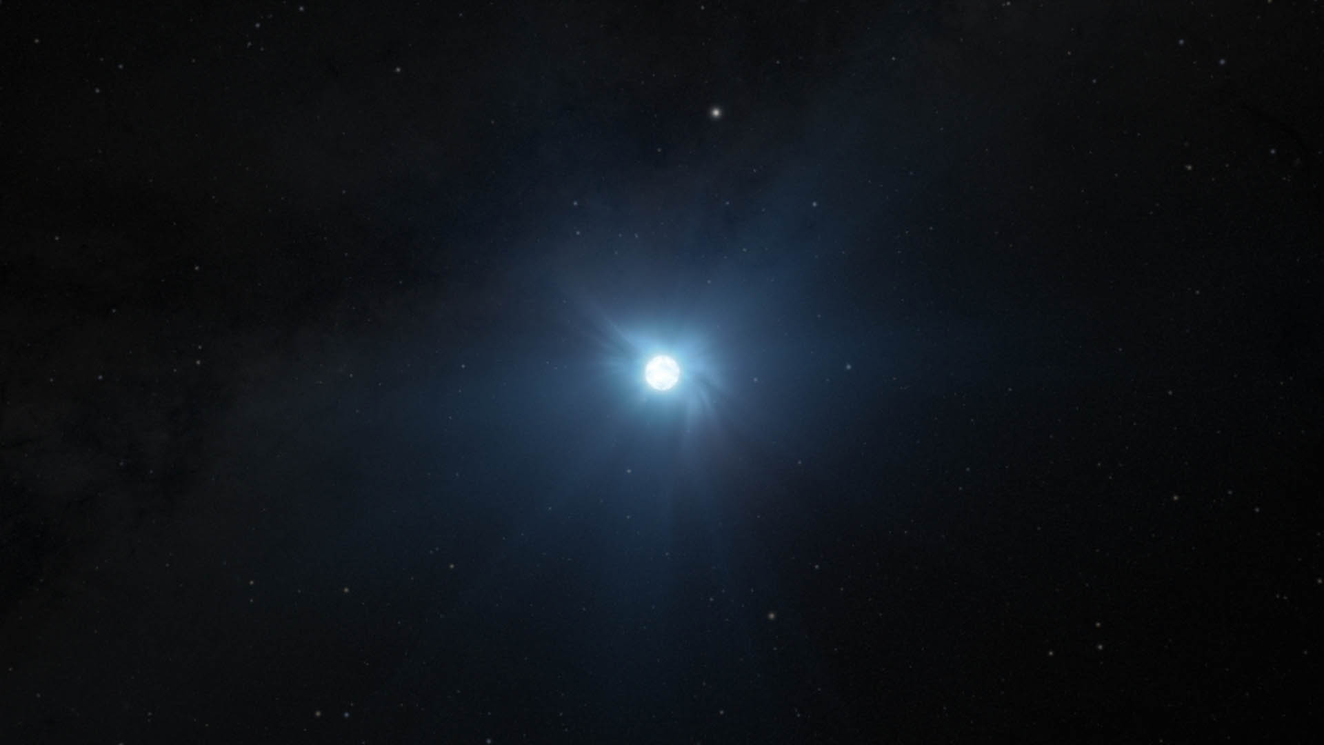 Illustration showing a small circular white object on the black background of space speckled with dim stars. The object is glowing, and rays of soft light emanate in all directions. The words “Artist’s Concept” are at the lower right.